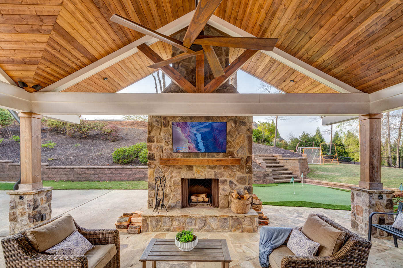 Custom built porch with fan, stone hearth, and backyard views by Silver Oak Remodeling in Atlanta,
