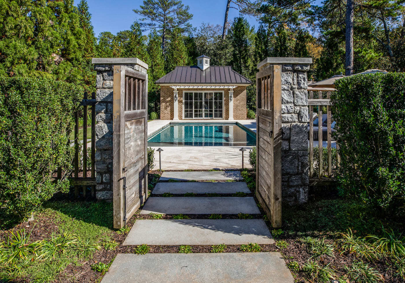 Custom home backyard with pool view through rustic wood gate by Silver Oak Remodeling in Atlanta, G