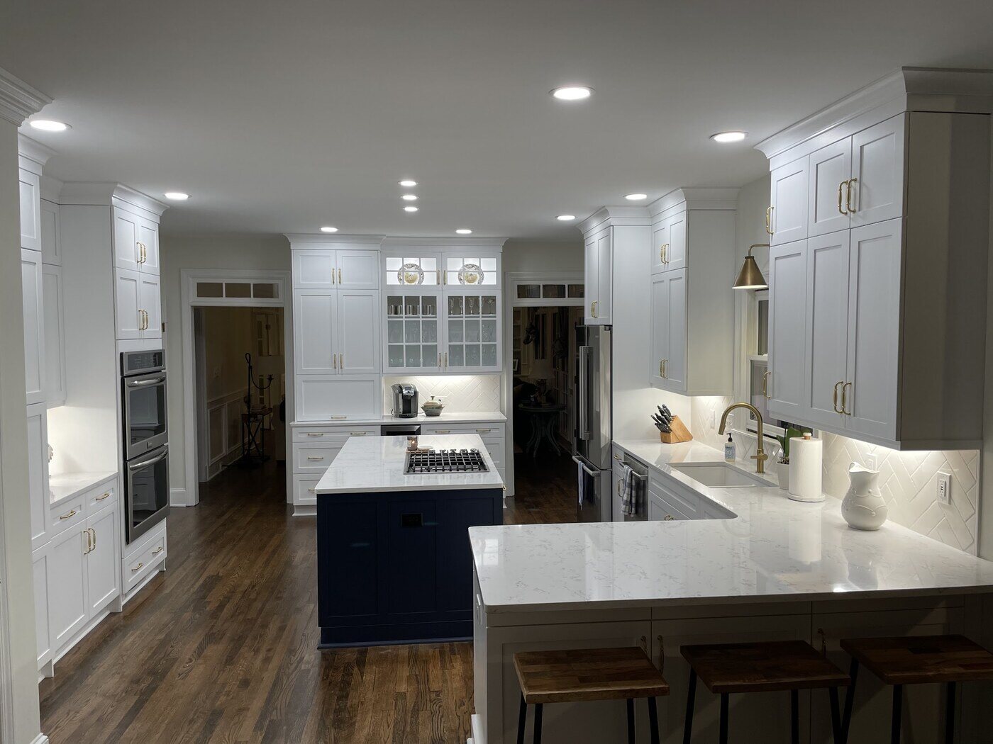 Bright white kitchen remodel in Atlanta, GA with navy island, gold fixtures, and custom cabinetry by Silver Oak Remodel