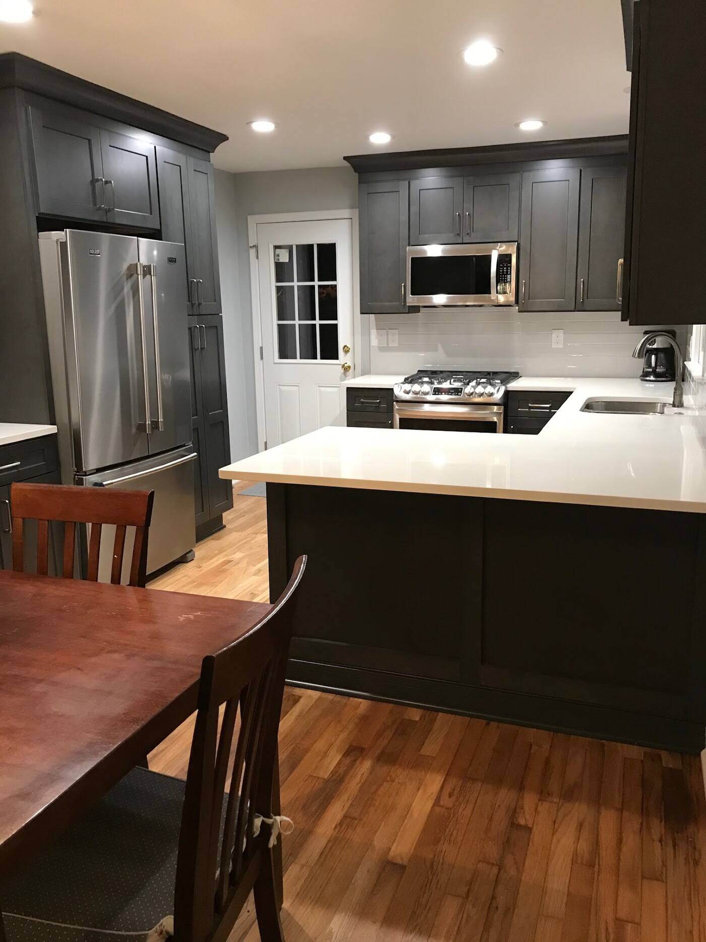 Modern kitchen remodel in Atlanta, GA featuring dark shaker cabinets, stainless steel appliances, and hardwood flooring by Silver Oak Remodel